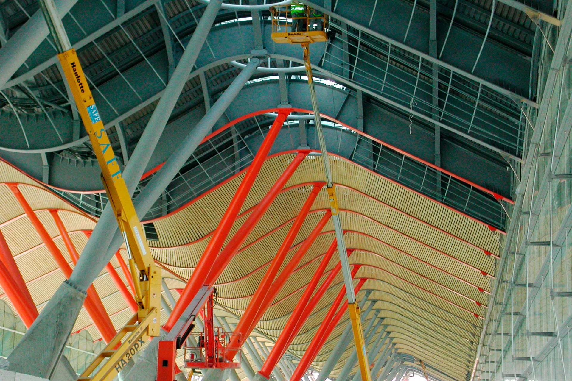 Plataformas elevadoras trabajando en la estructura metálica de la Terminal 4 de Madrid-Barajas durante la obra